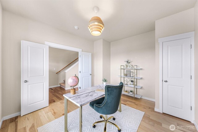 office space featuring light wood-type flooring and baseboards