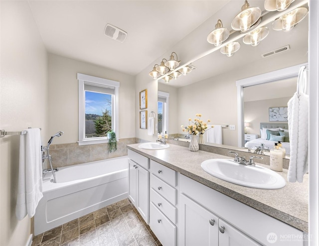 ensuite bathroom with double vanity, visible vents, a sink, and ensuite bathroom