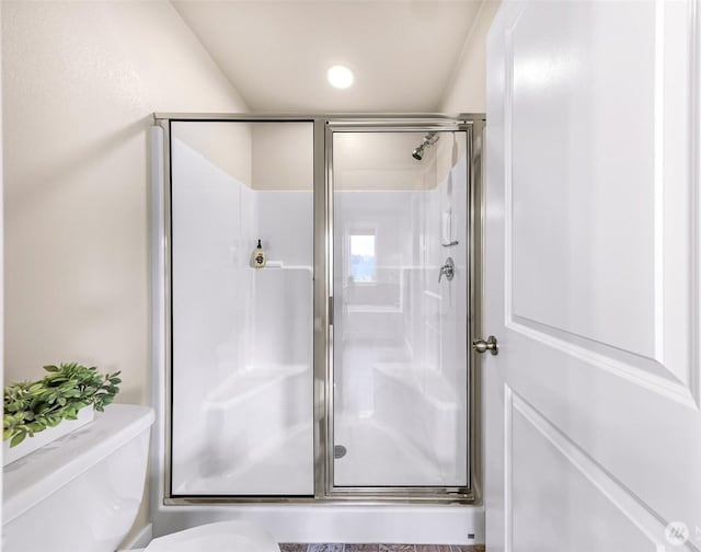 full bath featuring a stall shower and toilet