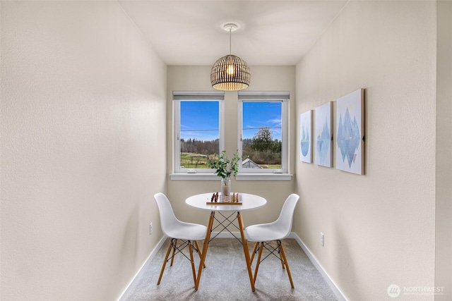 carpeted dining space featuring baseboards