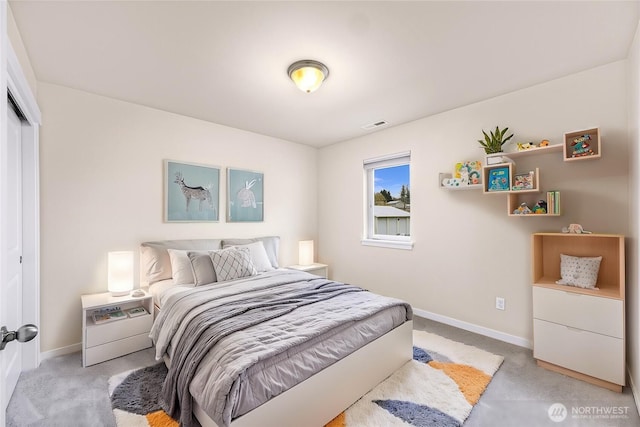 bedroom with baseboards, visible vents, a closet, and light colored carpet