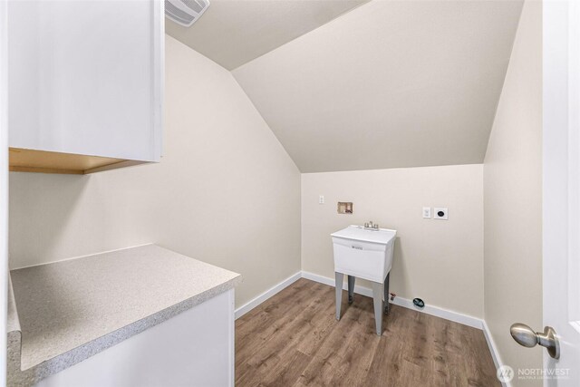 laundry room with cabinet space, baseboards, visible vents, hookup for an electric dryer, and light wood-type flooring