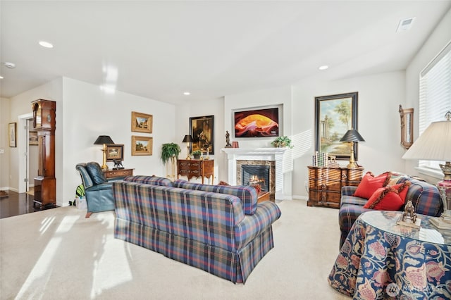 living area with carpet, recessed lighting, visible vents, a lit fireplace, and baseboards