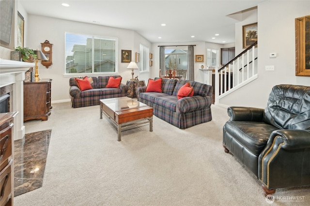 living room featuring carpet floors, recessed lighting, stairway, a premium fireplace, and baseboards