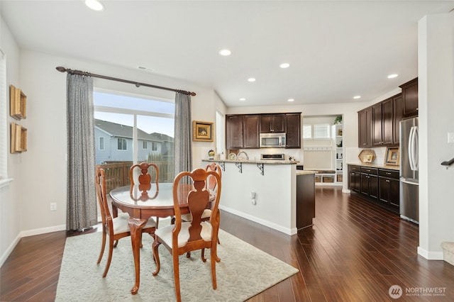 dining area featuring dark wood finished floors, plenty of natural light, baseboards, and recessed lighting