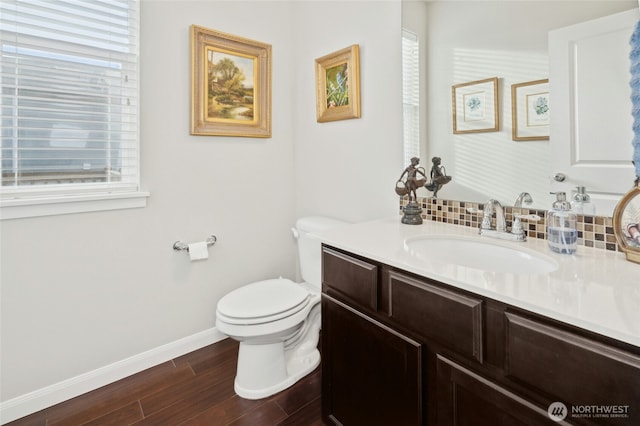 bathroom featuring vanity, plenty of natural light, wood finished floors, and toilet