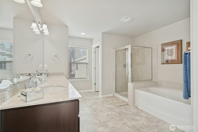 bathroom featuring a sink, a bath, double vanity, a stall shower, and an inviting chandelier