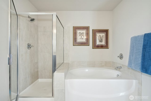 bathroom featuring a stall shower and a garden tub