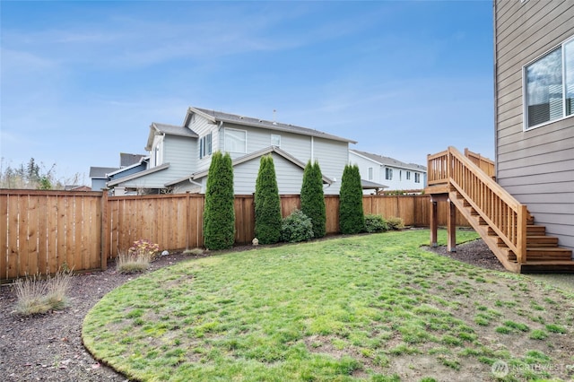 view of yard with a fenced backyard and stairway