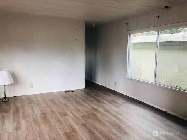 spare room featuring wood finished floors and visible vents