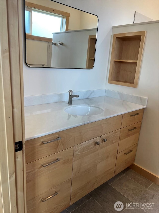 bathroom featuring vanity, baseboards, and tile patterned floors