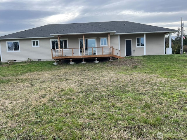 rear view of property featuring crawl space, roof with shingles, a lawn, and a wooden deck