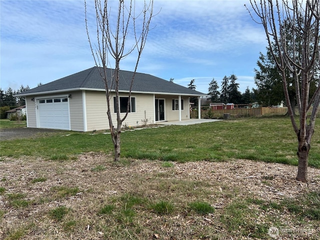 view of front of home with a garage, a patio area, fence, and a front yard