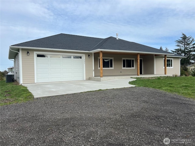 ranch-style house featuring a shingled roof, an attached garage, a front yard, central AC, and driveway