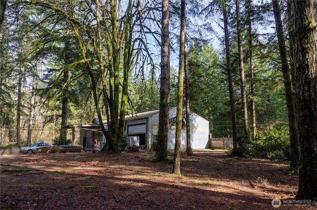 exterior space with fence and a forest view