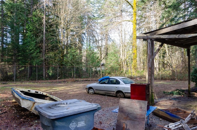 view of yard featuring a forest view and fence