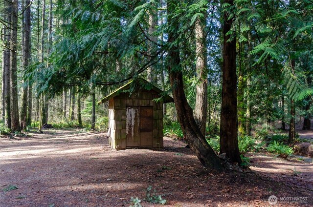 view of shed featuring a view of trees