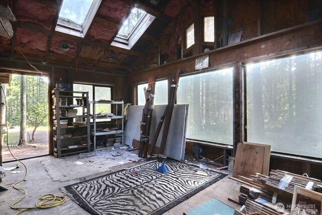 sunroom featuring vaulted ceiling with skylight