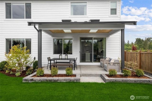 rear view of house featuring a yard, fence, and a patio