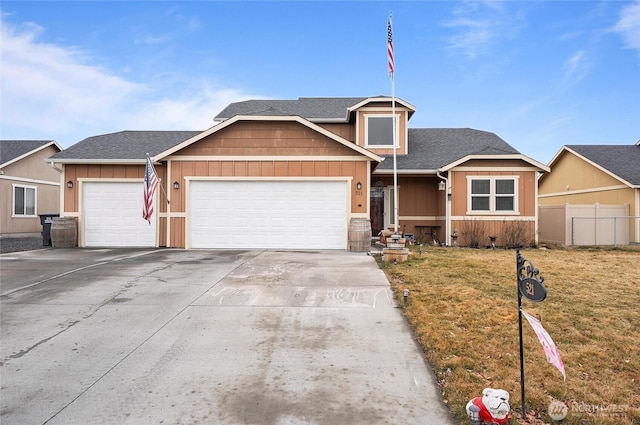 view of front of home with driveway, an attached garage, fence, a front lawn, and board and batten siding