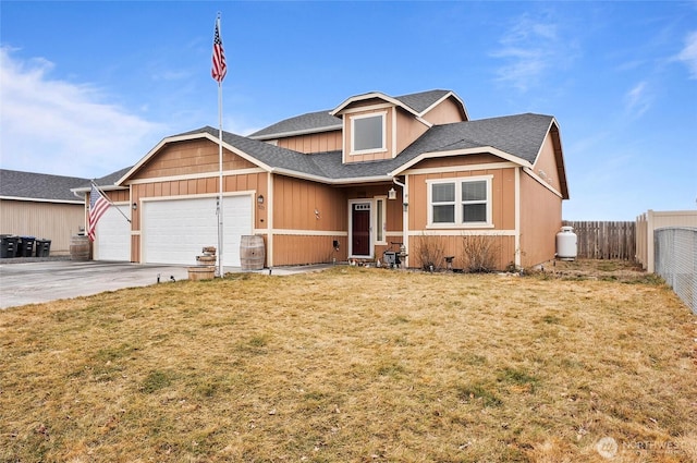 view of front facade with driveway, a shingled roof, an attached garage, fence, and a front yard