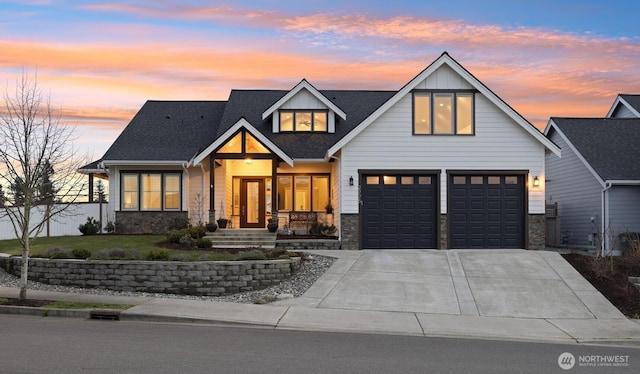 modern farmhouse featuring driveway, stone siding, an attached garage, and a lawn