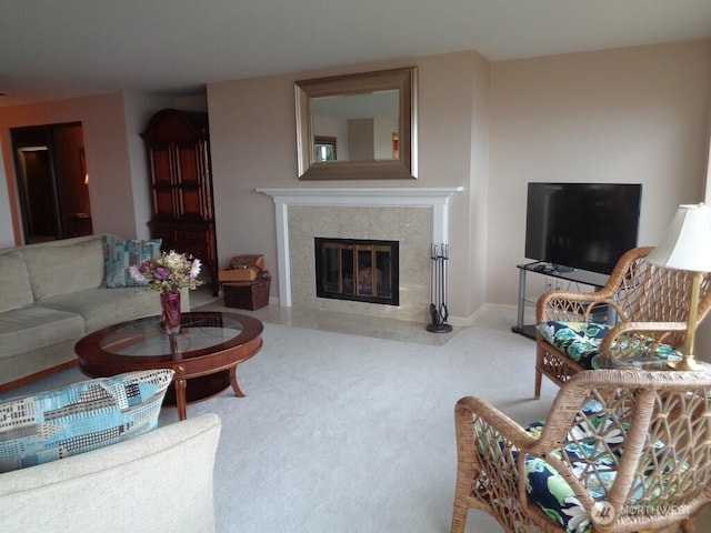 carpeted living room featuring a high end fireplace and baseboards