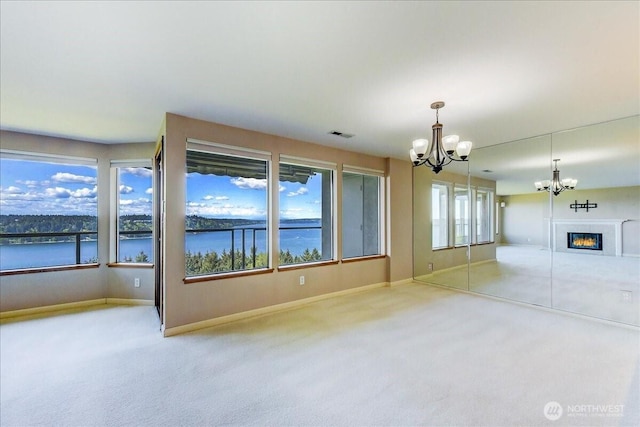 interior space featuring an inviting chandelier, visible vents, baseboards, and carpet floors