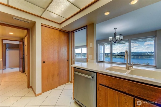 kitchen with a sink, visible vents, a chandelier, light countertops, and dishwasher