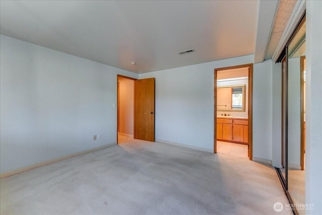 unfurnished bedroom featuring light colored carpet, visible vents, and baseboards