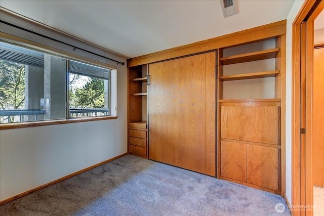 unfurnished bedroom featuring a closet, visible vents, carpet floors, and baseboards