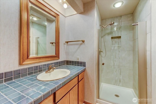 bathroom with a shower stall and vanity