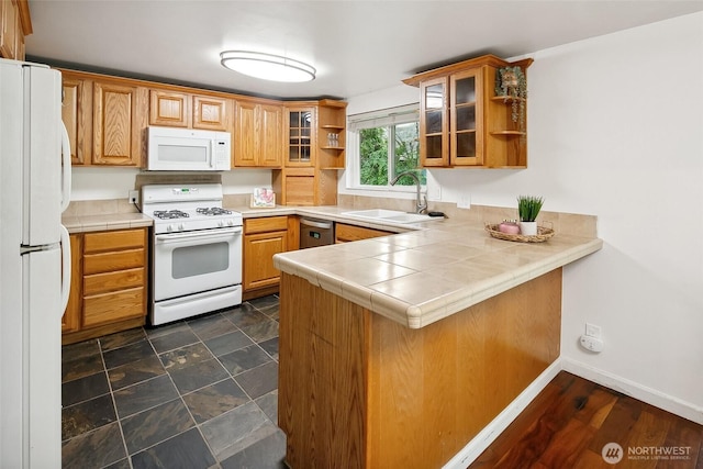 kitchen with a peninsula, white appliances, a sink, open shelves, and glass insert cabinets