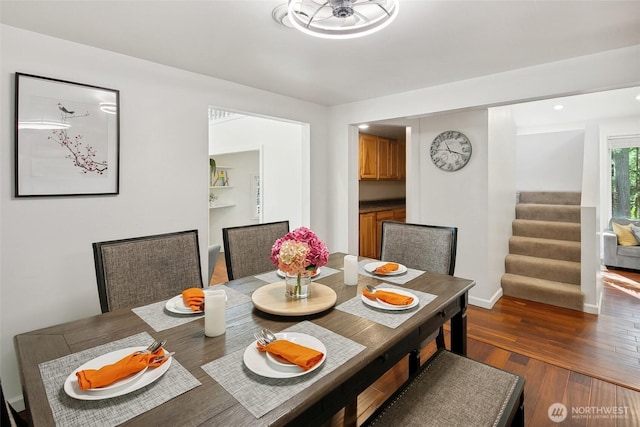 dining area with stairs, baseboards, and wood finished floors