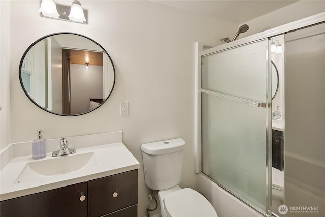 full bath featuring bath / shower combo with glass door, vanity, and toilet