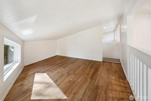 additional living space featuring recessed lighting, vaulted ceiling, baseboards, and wood finished floors