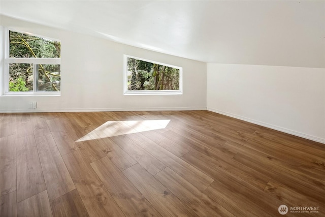 bonus room featuring vaulted ceiling, baseboards, and wood finished floors