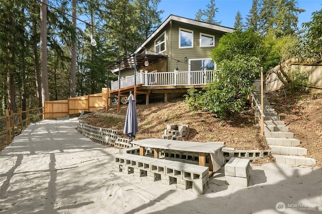 rear view of property featuring fence and a deck