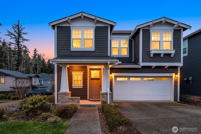 craftsman-style house featuring covered porch, driveway, and an attached garage