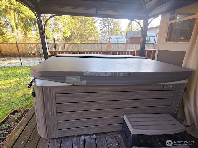 wooden terrace with a hot tub and fence