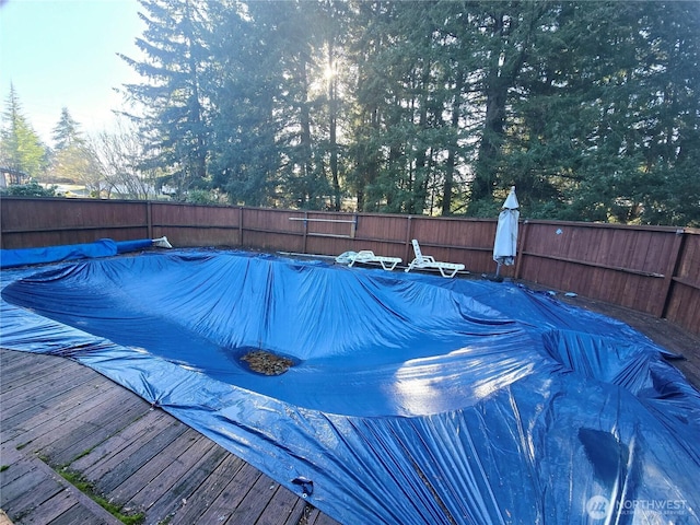 view of pool featuring a wooden deck, a fenced backyard, and a fenced in pool