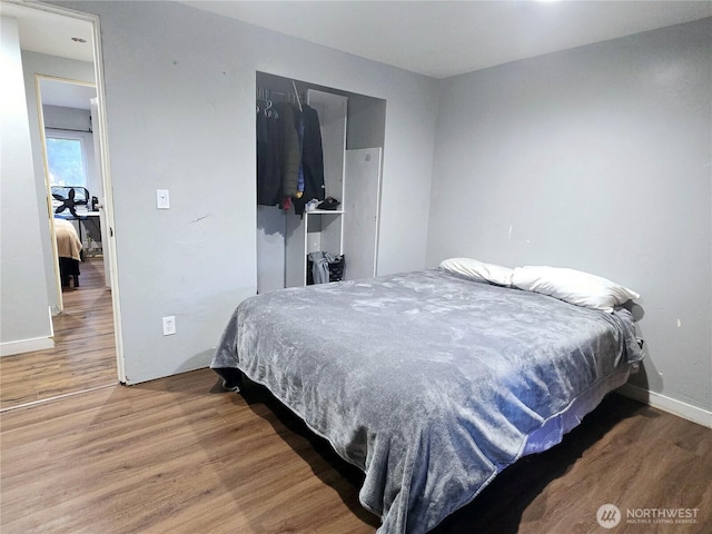 bedroom with a closet, baseboards, and wood finished floors