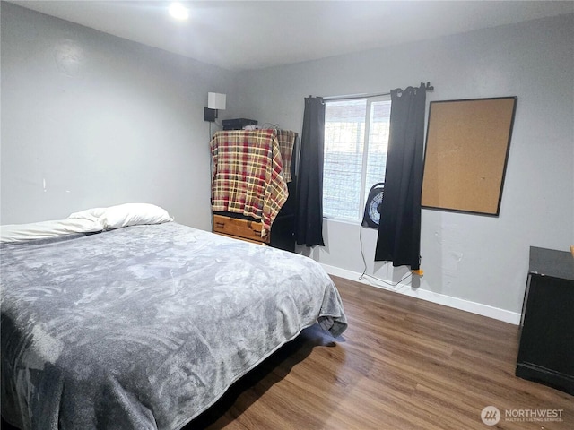 bedroom with wood finished floors and baseboards