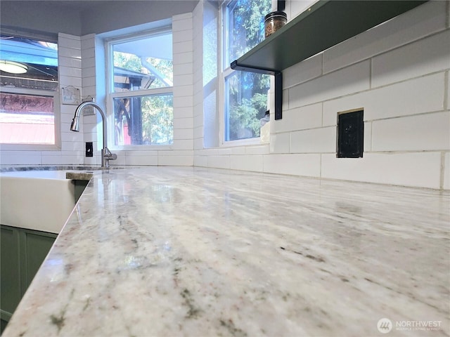 interior space with light stone countertops and a sink