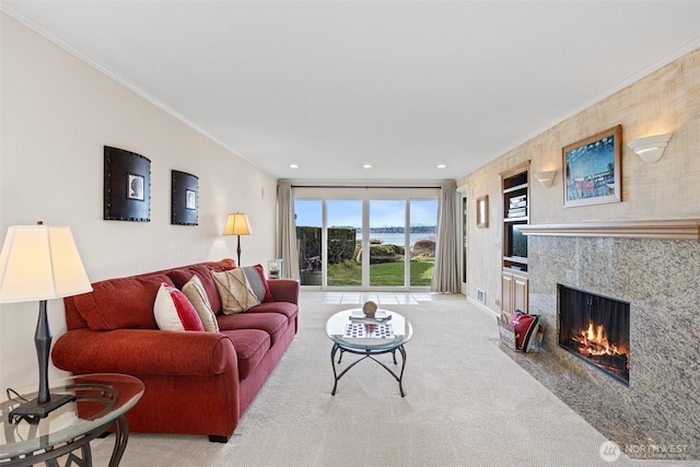 living room featuring light carpet, ornamental molding, a fireplace, and recessed lighting