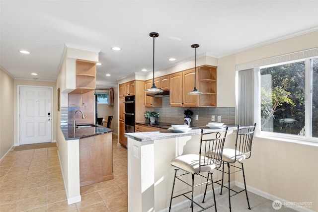 kitchen featuring open shelves, tasteful backsplash, a sink, a peninsula, and under cabinet range hood