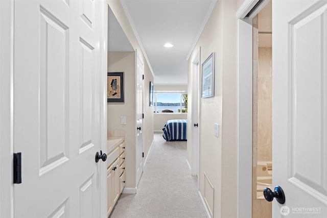 hallway with light carpet, baseboards, crown molding, and recessed lighting