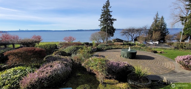 view of community with a patio area and a water view