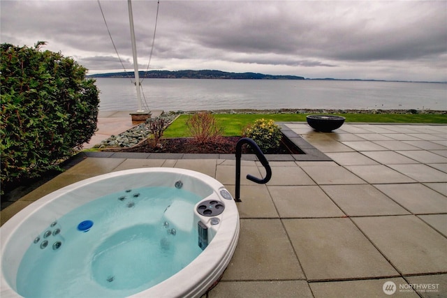 view of pool featuring a water view, an outdoor hot tub, and a patio area