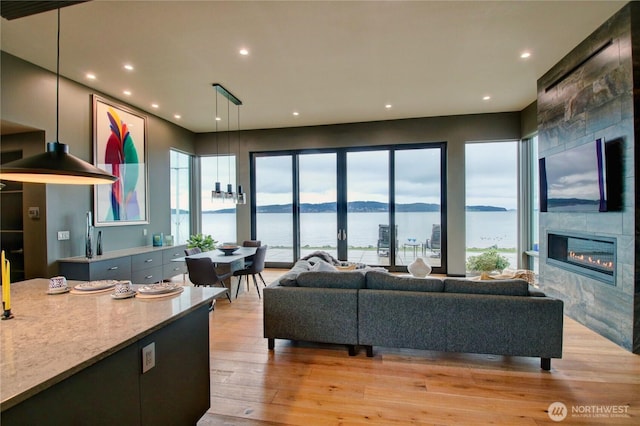 living room featuring a fireplace, recessed lighting, and light wood-type flooring